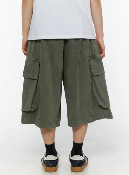 Men's Pigment Bermuda Cargo Shorts (Dark Green) IL507 Dark green back view on male model showing wide-leg silhouette rear cargo pockets and pigment-washed cotton fabric