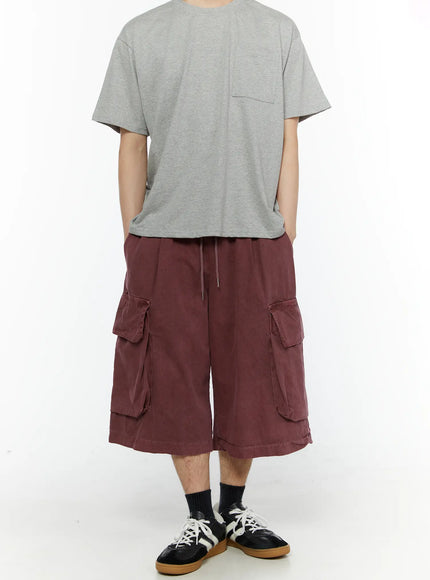 Men's Pigment Bermuda Cargo Shorts (Dark Pink) IL507 Dark Pink full-body front view on model with gray pocket tee and Adidas sneakers, wide-leg silhouette visible