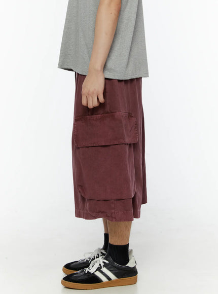 Men's Pigment Bermuda Cargo Shorts (Dark Pink) IL507 Dark Pink side view on model highlighting oversized cargo pocket flap and dropped hem, pigment-dyed cotton