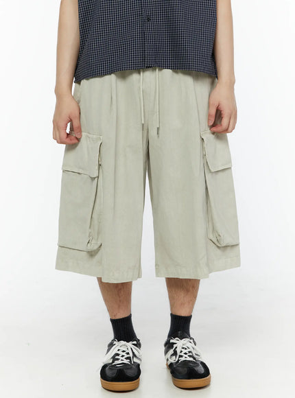 Men's Pigment Bermuda Cargo Shorts (Light Beige) IL507 Light Beige front mid-shot on male model showing dual cargo pockets and drawstring elastic waistband detail