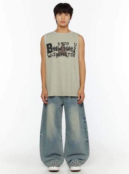 Men's Pigment Graphic Tank IL507 light beige full-body front shot on male model standing straight styled with wide-leg denim