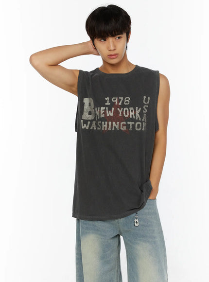 Men's Pigment Graphic Tank IL507 Dark gray front view on male model hand behind head posed with wide-leg jeans showing vintage graphic detail