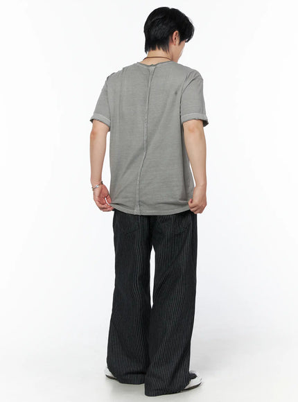 Men's Pigment Washed T-Shirt IU523 Gray full-body back shot on male model holding hem showing center back seam and relaxed silhouette with black pinstripe trousers