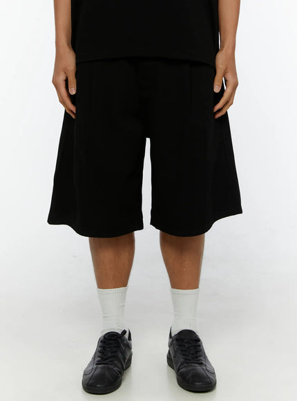 LEWKIN Men's Pintuck Bermuda Shorts IL515 Black front shot on male model wearing black tee and sneakers, wide-leg silhouette, size S