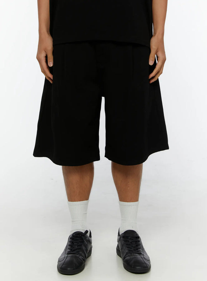 LEWKIN Men's Pintuck Bermuda Shorts IL515 Black front shot on male model wearing black tee and sneakers, wide-leg silhouette, size S
