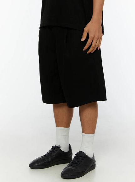 Men's Pintuck Bermuda Shorts IL515 Black side close-up on male model showing wide-leg hem, pintuck detail, and black sneakers with white socks