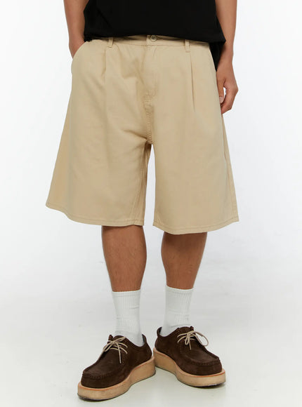 LEWKIN Men's Pintuck Cotton Bermuda Shorts IL515 Beige front close-up on model wearing black tee and brown suede shoes showing pleated waistband and wide leg