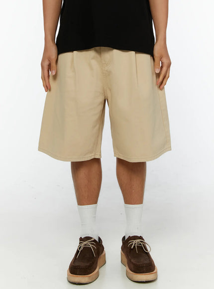 Men's Pintuck Cotton Bermuda Shorts IL515 Beige front view on model standing straight showing full length cotton twill fabric and wide relaxed silhouette
