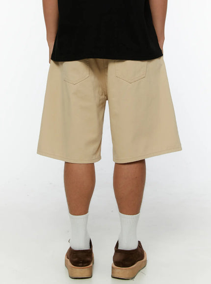 Men's Pintuck Cotton Bermuda Shorts IL515 Beige flat-lay front showing button waistband belt loops pintuck pleats side pockets and wide leg cotton construction