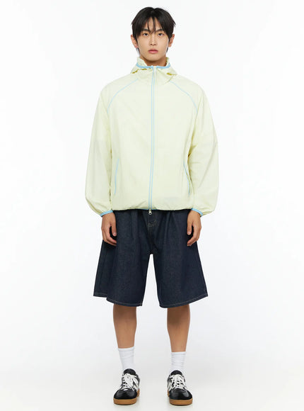 Men's Pintuck Wide Bermuda Shorts IL528 Dark blue full-body front styling shot on model in light yellow zip-up hooded jacket and sneakers