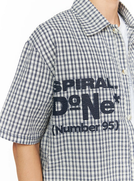 Men's Plaid Graphic Button-Up Shirt IL528 light beige close-up detail shot showing spiral swirl and star graphic embroidery with WAVE CLUB text and seersucker texture