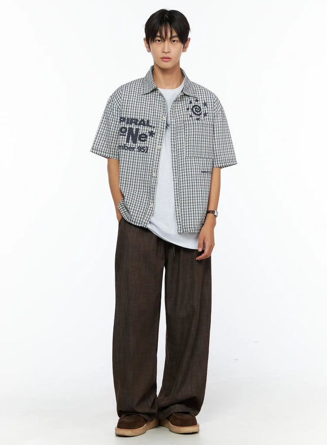 LEWKIN Men's Plaid Graphic Button-Up Shirt IL528 Light beige front full-body shot on male model layered over white tee with wide-leg brown trousers