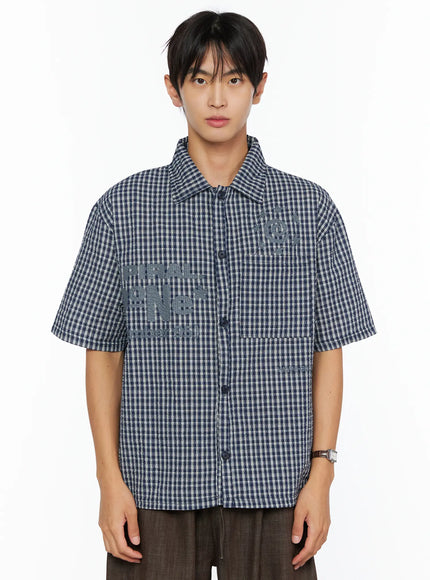 Men's Plaid Graphic Button-Up Shirt IL528 navy front crop shot on male model showing tonal SPIRAL graphic embroidery button placket and boxy seersucker fit