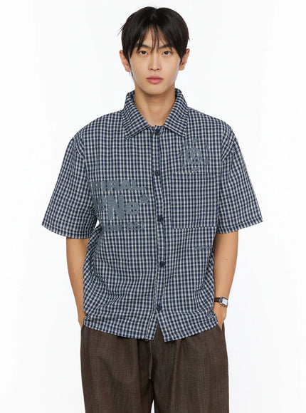 Men's Plaid Graphic Button-Up Shirt IL528 navy front crop shot on male model showing tonal SPIRAL graphic embroidery and button placket on seersucker plaid
