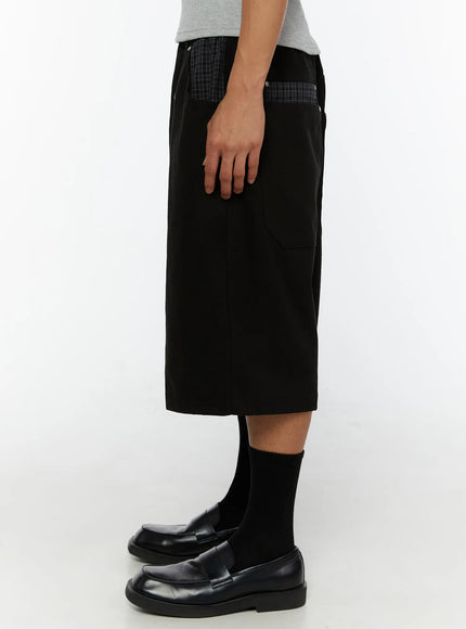 Men's Plaid Pocket Bermuda Shorts (Black) IL507 side view on male model showing plaid-accented back yoke panel, silver studs and wide-leg length profile