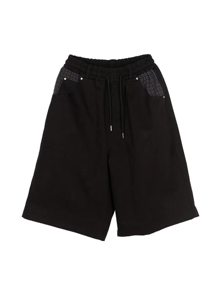 Men's Plaid Pocket Bermuda Shorts (Black) IL507 flat-lay front view showing elastic drawstring waistband, gray plaid contrast pockets and silver stud rivets