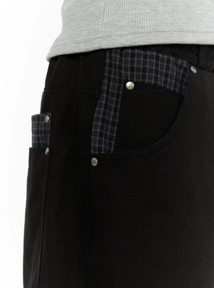 Men's Plaid Pocket Bermuda Shorts (Black) IL507 close-up detail of front pocket with dark gray plaid contrast lining, silver rivet studs on waistband