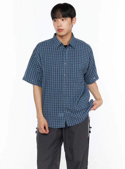 Men's Plaid Roll-Up Short Sleeve Shirt IL514 Blue front shot on model looking away showing blue plaid pattern chest pocket and open layered styling over black tee