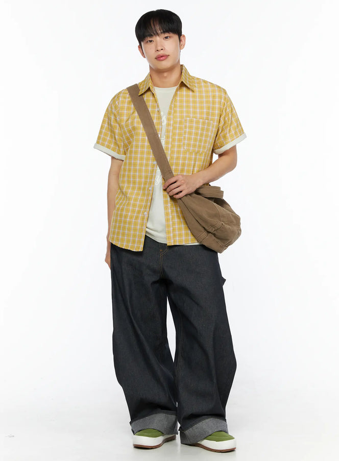 LEWKIN Men's Plaid Short Sleeve Shirt IL510 Yellow full-body front shot on model standing with brown crossbody bag layered over white graphic tee and dark wide-leg jeans