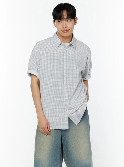 Men's Plaid Short Sleeve Shirt IU529 Grey front close-up shot on male model showing rolled cuffs point collar and fine grid check texture with subtle smile
