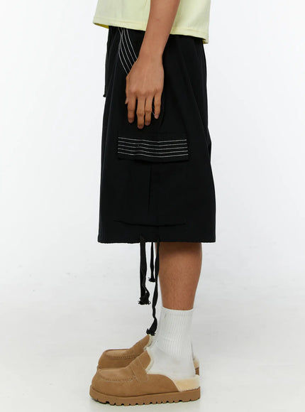 Men's Pocket Cargo Shorts IL515 Black side shot on model highlighting white multi-line stitch detail on thigh and flap cargo pocket