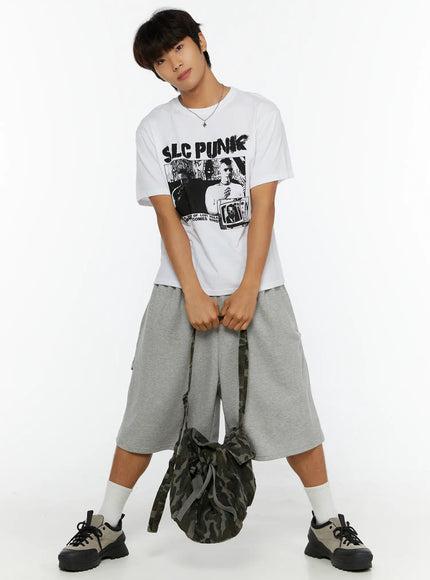 LEWKIN Men's Punk Graphic T-Shirt IL513 White M/L full-body front shot on male model posed with hands clasped holding camo bag styled with gray shorts