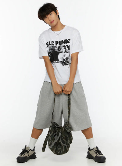 LEWKIN Men's Punk Graphic T-Shirt IL513 White M/L full-body front shot on male model posed with hands clasped holding camo bag styled with gray shorts