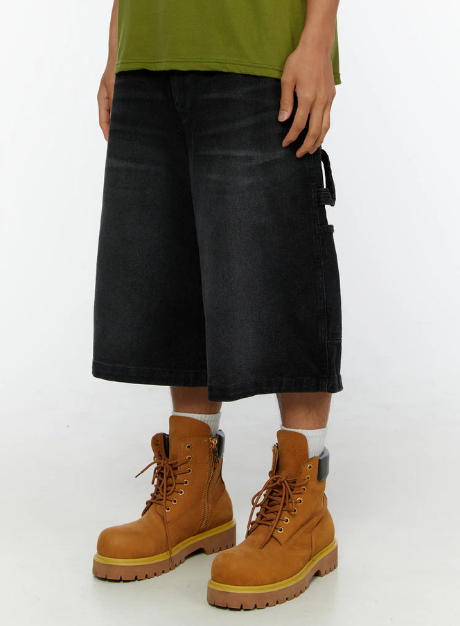 Men's Relaxed Denim Carpenter Shorts IL513 Black angled close-up on model, side cargo pocket and loop detail visible, styled with olive tee and tan boots