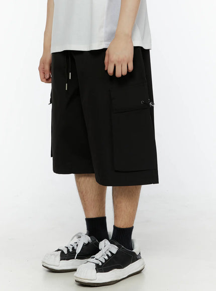 Men's Relaxed Fit Cargo Shorts (Black) IL509 black side shot on model showing cargo pocket placement drawstring waist and wide-leg cut
