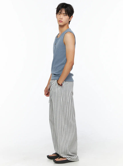 Men's Relaxed-Fit Pajama Pants IL520 Dark blue full side shot on male model showing straight relaxed wide-leg fit vertical stripe pattern and length over black flip flop sandals