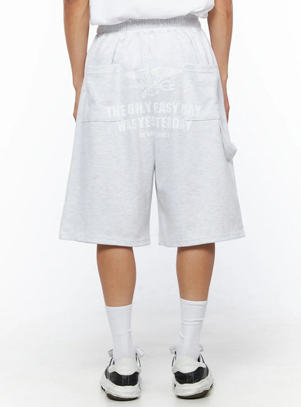 LEWKIN Men's Relaxed-Fit Sweat Shorts IL515 Light gray back view on model wearing white tee and sneakers, US Navy Seals graphic print on heathered cotton fleece
