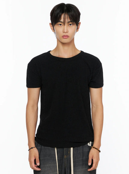 Men's Ribbed Slim-Fit T-Shirt IL520 Black close-up front shot on male model showing ribbed knit texture crew neckline and slim fit silhouette with dark wide-leg pants