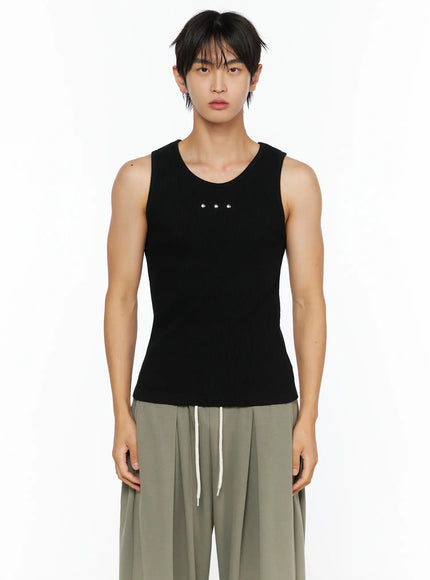 Men's Ribbed Studded Tank Top IL528 Black cropped front shot on male model showing U-neckline and three silver dome studs on ribbed knit fabric paired with olive trousers