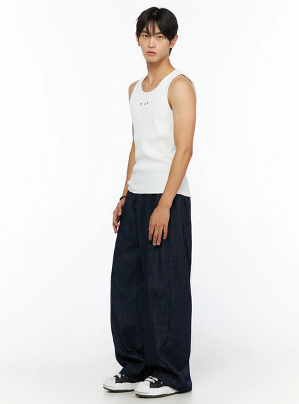 Men's Ribbed Studded Tank Top IL528 White side shot on male model standing styled with navy wide-leg denim trousers and white sneakers