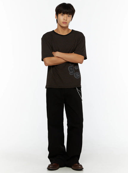 Men's Semi-Flared Black Pants IL509 Black full-body front view on model with arms crossed styled with striped graphic tee and brown loafers