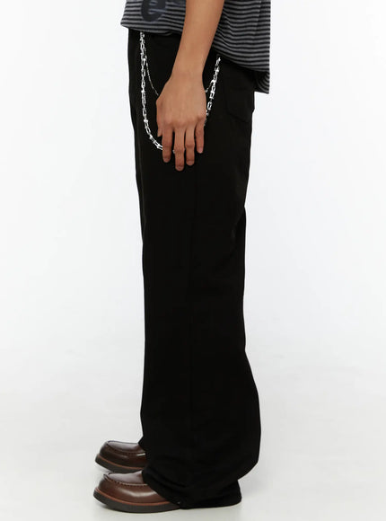 Men's Semi-Flared Black Pants IL509 Black side view on model holding silver chain detail showing wide-leg cut and fabric drape to ankle