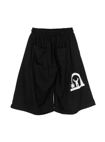 Men's Shooting Star Printed Shorts (Black) IL509 flat-lay back view showing wide-leg silhouette, elastic waistband, and white arch figure graphic print on lower leg