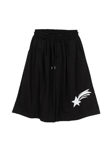 Men's Shooting Star Printed Shorts (Black) IL509 flat-lay front view showing elastic drawstring waistband, wide-leg cut, and white shooting star graphic on hem