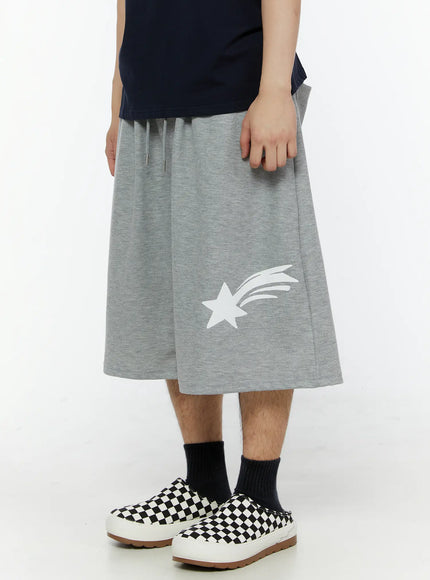 Men's Shooting Star Printed Shorts (Gray) IL509 Gray close-up side view on model showing white shooting star graphic on left leg panel, drawstring waistband detail, wide-leg heathered cotton