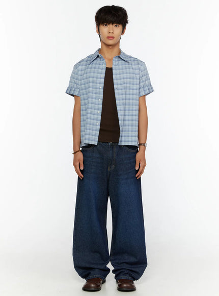 Men's Short Sleeve Plaid Shirt IL515 Blue full front shot on model standing straight, open plaid shirt over dark tank top with wide-leg denim