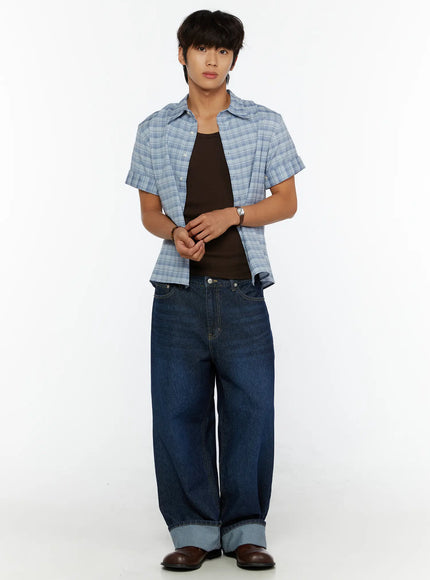 Men's Short Sleeve Plaid Shirt IL515 Blue full front shot on model clasping hands at waist, open plaid shirt over dark tank with wide-leg jeans