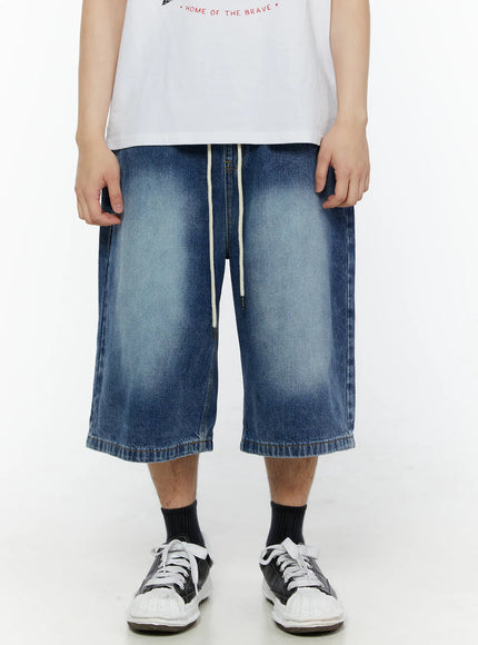 Men's Star Bolt Graphic Print Jorts (Dark Blue) IL507 front close-up on model showing washed dark blue denim fabric, cream drawstring, faded thigh detail and wide-leg cut