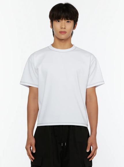 Men's Stitched Cropped T-Shirt IL513 White front close-up on male model standing straight, showcasing crewneck and contrast stitched cropped hemline