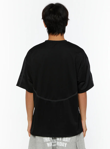 Men's Stitched T-Shirt IL513 Black back shot on male model standing upright showing curved white contrast stitch arc across back panel