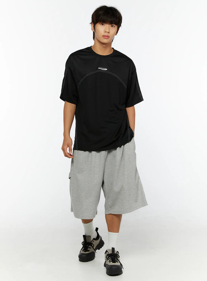 LEWKIN Men's Stitched T-Shirt IL513 Black M/L full-body front shot on male model styled with gray shorts and chunky sneakers