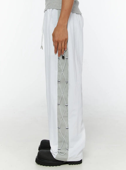 Men's String Detail Track Pants IL515 White side view on model showing gray contrast panel with white lace cord and black cord stopper hardware detail