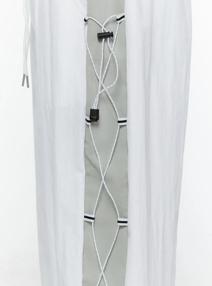 Men's String Detail Track Pants IL515 White close-up detail of gray side panel with white rope lace-up pattern and black cord lock toggle hardware