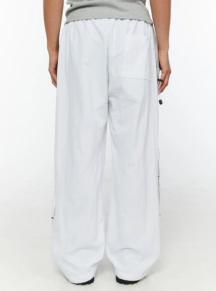 Men's String Detail Track Pants IL515 White back view on model showing wide-leg silhouette elastic waistband back pocket and side lace cord panels