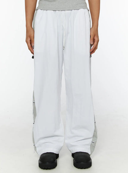 Men's String Detail Track Pants IL515 White front view on model cropped at waist showing elastic drawstring waistband and gray side panels with cord trim