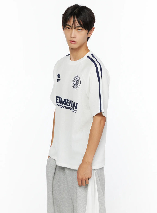 LEWKIN Men's Stripe Detail Tee IL528 White side view on male model wearing grey sweatpants, navy stripe detail on shoulder, ribbed texture
